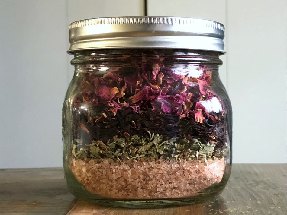 herbs and bath salt layered in a jar