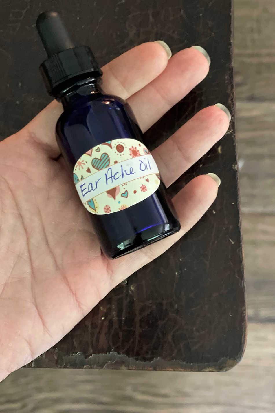 bottle of herbal earache oil in hand